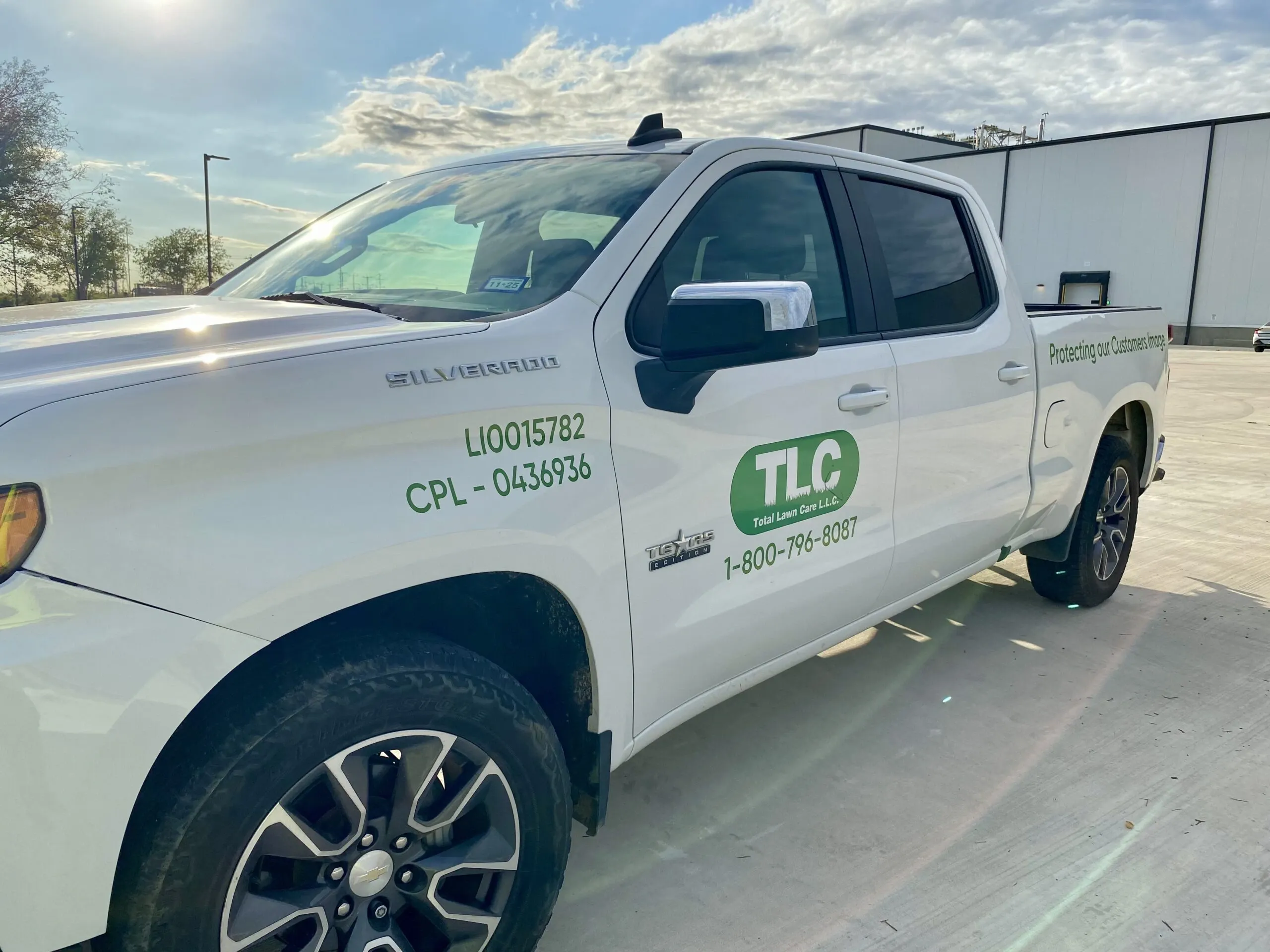 A professional TLC Total Lawn Care service truck positioned for a site assessment at a Comal County property