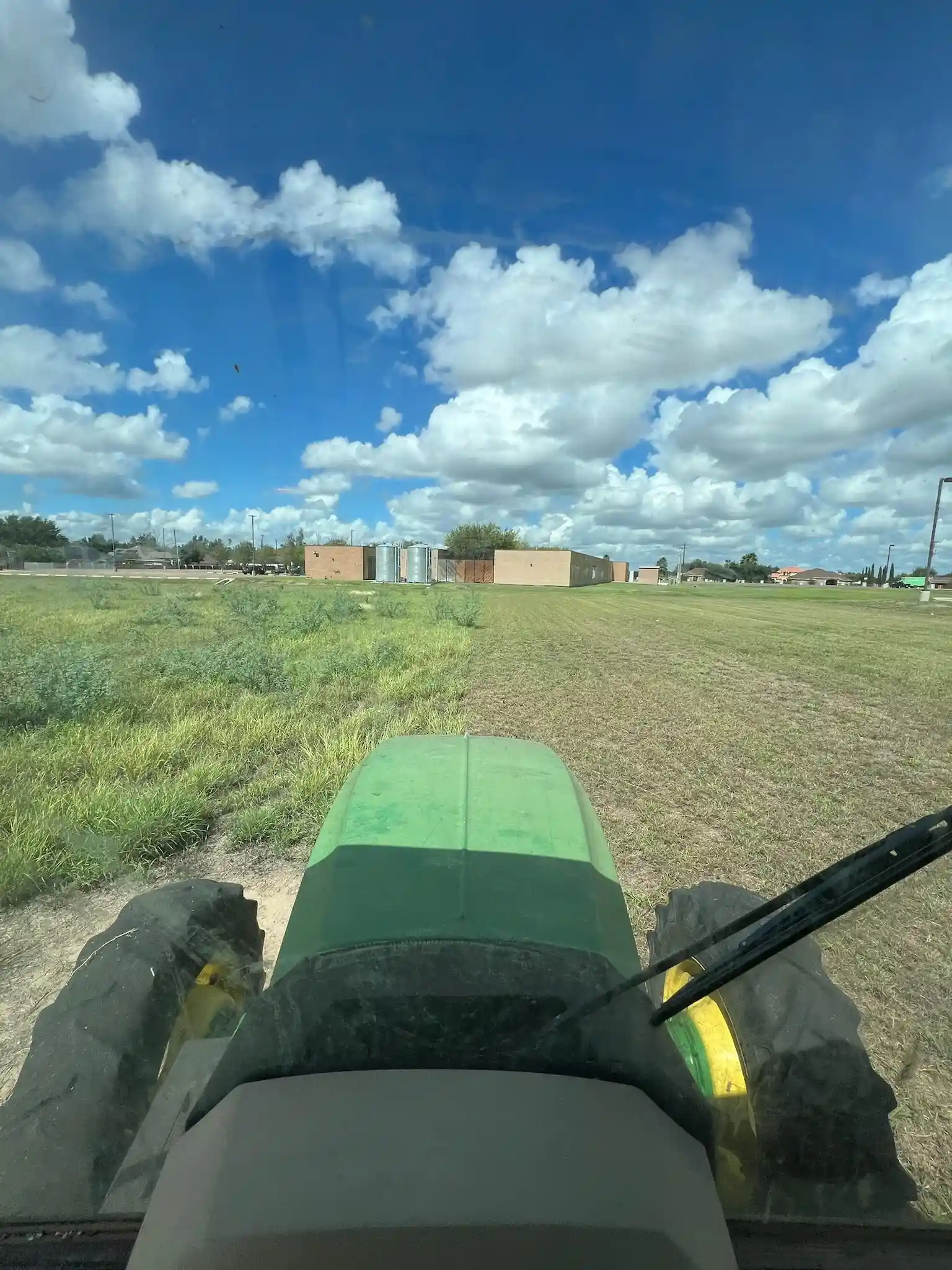 John Deere tractor clearing brush on a rural property for Boerne land clearing services